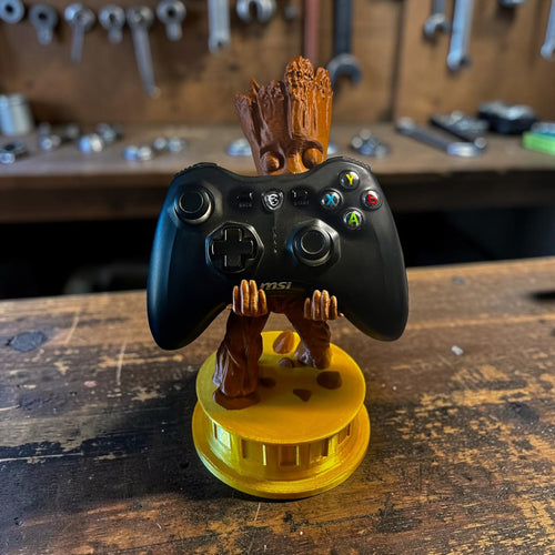 3D printed Groot controller holder holding an MSI gaming controller on a wooden workbench